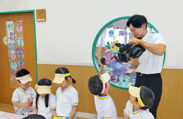 園で園児を撮影する寿田